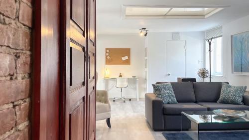 a living room with a couch and a table at Quebec Grand Appartement by Hébergements DCL in Quebec City