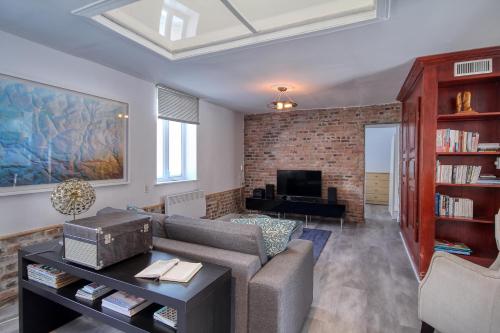 a living room with a couch and a tv at Quebec Grand Appartement by Hébergements DCL in Quebec City