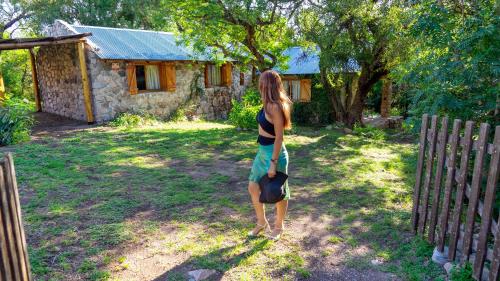 a woman is standing in front of a house at Glaventura, Casa de Montaña in Los Cocos