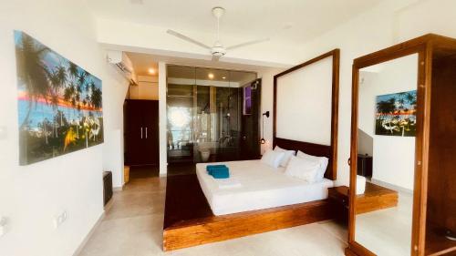 a bedroom with a bed and a mirror at Villa LA Kurumba in Ambalangoda