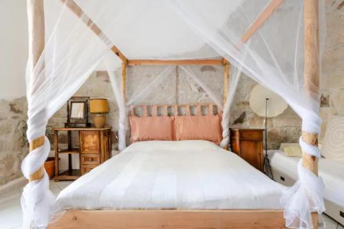 una camera da letto con un letto a baldacchino di DUAS PEDRAS, private apartment in the heart of Bosa a Bosa
