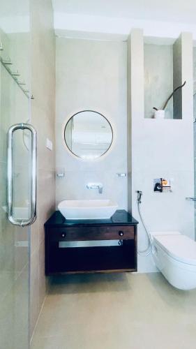 a bathroom with a sink and a mirror and a toilet at Villa LA Kurumba in Ambalangoda