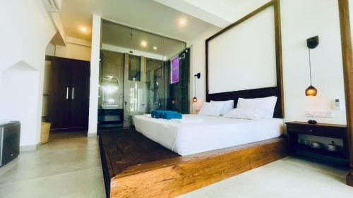 a bedroom with a large white bed and a large mirror at Villa LA Kurumba in Ambalangoda