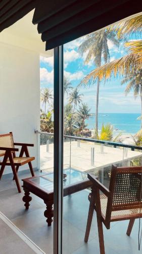 a balcony with a view of the beach and the ocean at Villa LA Kurumba in Ambalangoda
