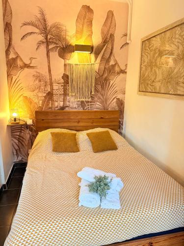 - un lit avec 2 oreillers et une plante dans l'établissement Coeur de Juan, Calme, 300m plages - EASY CHECK-IN, à Antibes