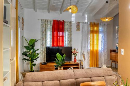- un salon avec un canapé et des rideaux colorés dans l'établissement villa bouginvillier, à Pointe-Noire