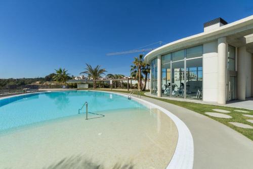 a large swimming pool in front of a building at Penthouse Casa SARA, Greenhills, La Zenia, Orihuela Costa in Orihuela