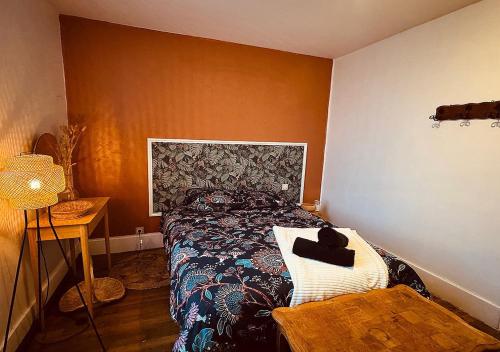 Un dormitorio con una cama y una mesa con un sombrero. en Le Charme du Bouchon Troyen - Cosy & Central, en Troyes