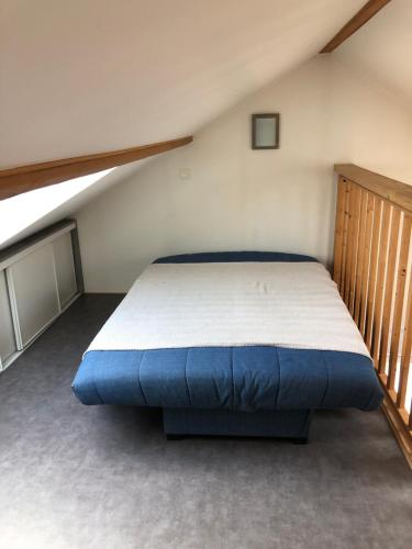 une chambre avec un grand lit dans un grenier dans l'établissement Charmante maison proche Wimereux, à Wimille