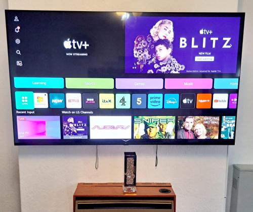 a flat screen tv hanging on a wall at Cozy 2BR Home Leeds Free Parking & Wifi Pets Welcome in Belle Isle