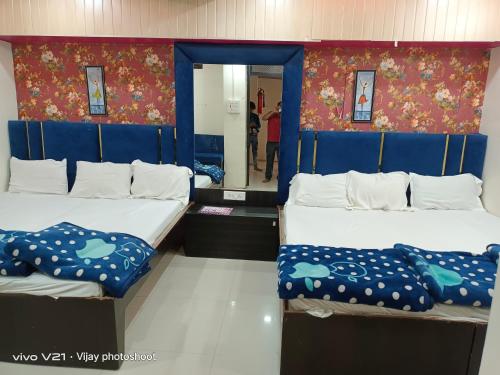 two beds with blue dividers in a room at Shree Sampatbai yatri ghar in Ujjain