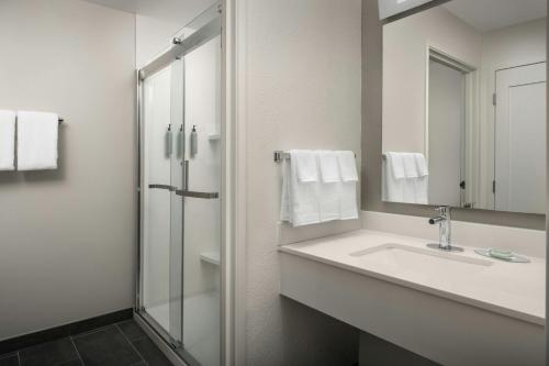 a white bathroom with a sink and a shower at Courtyard by Marriott Dayton Beavercreek in Beavercreek