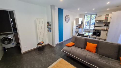 - un salon avec un canapé brun et des oreillers orange dans l'établissement La Luziole 3 étoiles, en vacances ou cure, été ou hiver, comme chez vous, à Luz-Saint-Sauveur