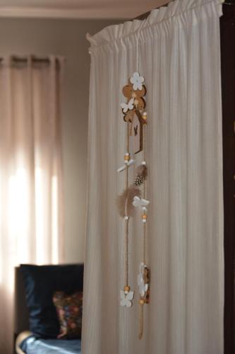 a white curtain with a shelf with stuffed animals at Téli Berek Vendégház in Abod