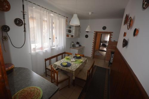 a kitchen and dining room with a table and chairs at Téli Berek Vendégház in Abod