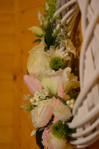a bunch of white and pink flowers in a basket at Téli Berek Vendégház in Abod