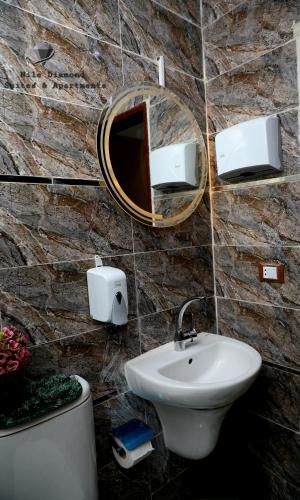 a bathroom with a sink and a mirror on a wall at Nile Diamond Suites in Cairo
