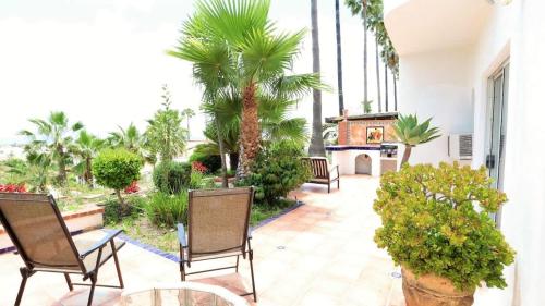 a patio with chairs and palm trees in a building at Tijuana Beach View & Patio in Tijuana