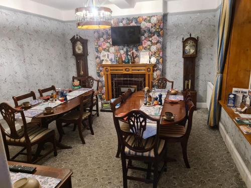 a dining room with tables and chairs and a fireplace at Upper Eyton Farmhouse B&B in Shrewsbury