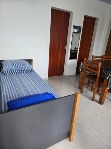 a bed in a room with a chair and a table at Recanto Dos Vargas in Florianópolis