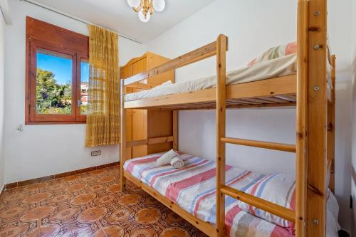 Un dormitorio con dos literas y una ventana. en Casa Calafell, en Segur de Calafell