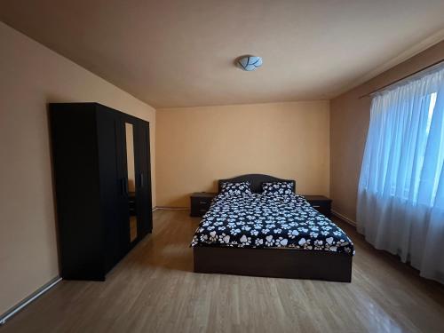 a bedroom with a bed and a window at Country house Egomer in Călugări