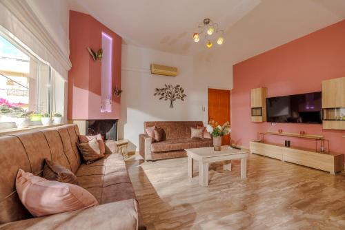 a living room with a couch and a table at Satisfy Holiday Escape Apartment for 2-7 Pax in Limín Khersonísou