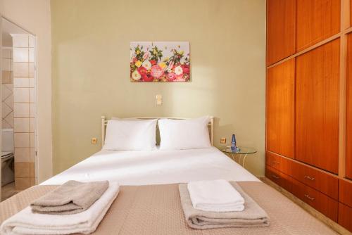 a bedroom with a white bed with towels on it at Satisfy Holiday Escape Apartment for 2-7 Pax in Limín Khersonísou