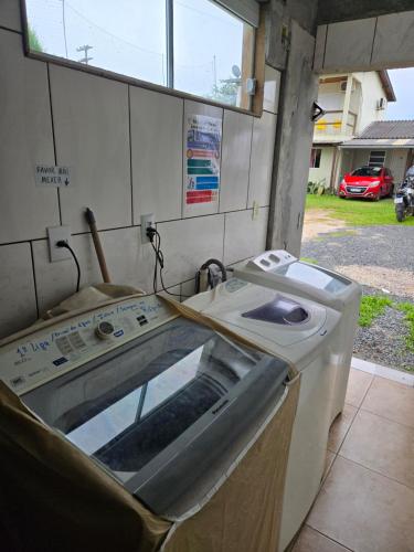 a washing machine in a room with a window at Recanto Dos Vargas in Florianópolis