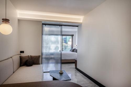 a living room with a glass door with a bed at L'Avventura Suites in Athens