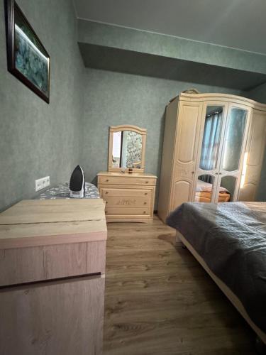 a bedroom with two beds and a dresser and a mirror at Cosy Nest in Tbilisi City