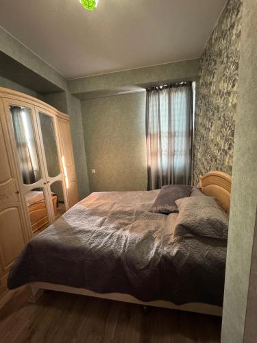 a bedroom with a large bed and a window at Cosy Nest in Tbilisi City