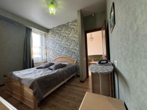 a bedroom with a bed and a table and a mirror at Cosy Nest in Tbilisi City