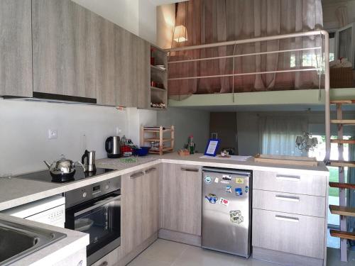 a kitchen with wooden cabinets and a stainless steel refrigerator at Orma, pet friendly retreat studio in Órma