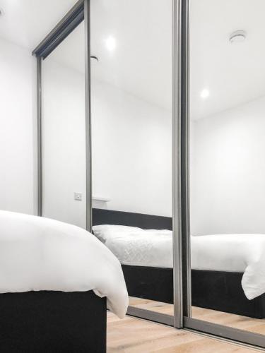 a bedroom with two beds and a mirror at 1-BR Flat next to Heathrow Airport London, 3-Beds, Free Parking in Harmondsworth