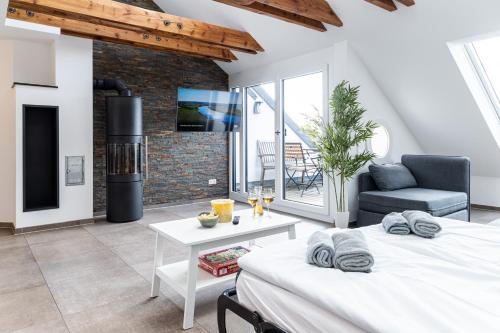 a bedroom with a bed and a living room with a fireplace at living TIMELESS - Apartments zum roten Lamm- Bad Krozingen in Bad Krozingen