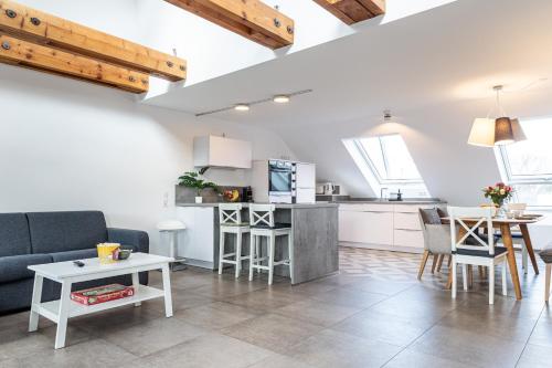a kitchen and living room with a couch and a table at living TIMELESS - Apartments zum roten Lamm- Bad Krozingen in Bad Krozingen