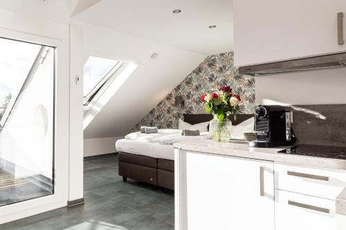 a room with a bed and a table with flowers at living TIMELESS - Apartments zum roten Lamm- Bad Krozingen in Bad Krozingen