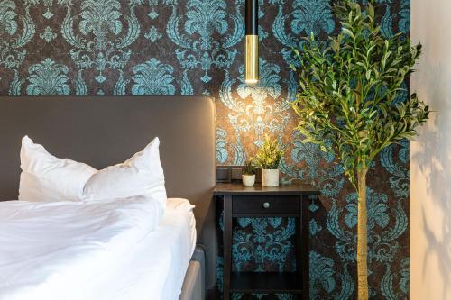 a bedroom with a bed and a plant on a table at living TIMELESS - Apartments zum roten Lamm- Bad Krozingen in Bad Krozingen