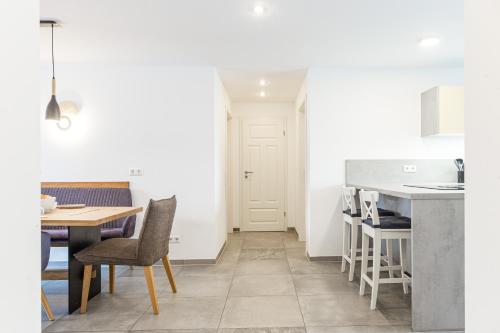 a kitchen and dining room with a table and chairs at living TIMELESS - Apartments zum roten Lamm- Bad Krozingen in Bad Krozingen