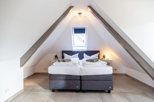 a bedroom with a bed in the attic at living TIMELESS - Apartments zum roten Lamm- Bad Krozingen in Bad Krozingen