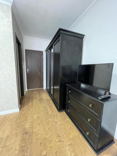 a black dresser with a television on top of it at Country house Egomer in Călugări