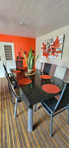 a dining room with a black table and chairs at Villa élégante avec jardin au Lamentin et piscine privée. in Le Lamentin