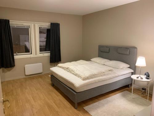 Un dormitorio con una cama en una habitación con ventana. en 2 bedrooms apartment, en Trondheim