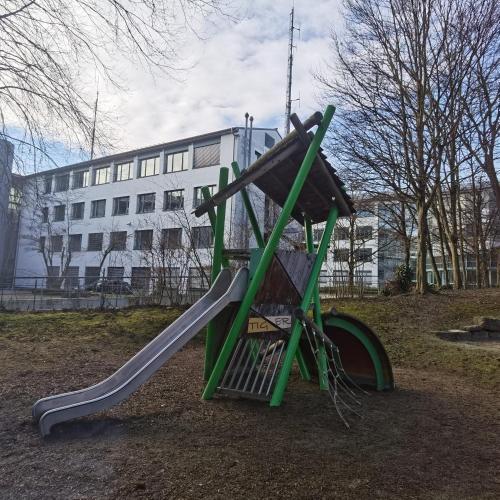 un parco giochi con uno scivolo in un parco di Sonnenschein2L mit Terrasse und Garten a Friedrichshafen