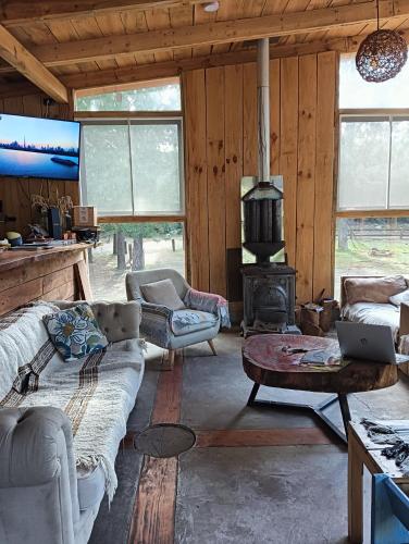 a living room with a couch and a stove at Refugio Silvestre Parque Nacional Siete Tazas-Salida a río y pesca in El Bolsico