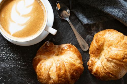 two croissants and a cup of coffee and a spoon at Sheraton Puerto Rico Resort & Casino in San Juan