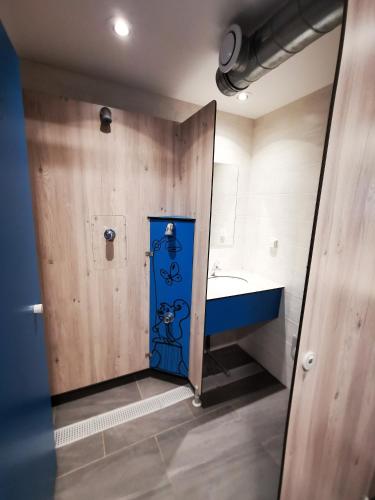 La salle de bains est pourvue d'une porte bleue et d'un lavabo. dans l'établissement Caravane 4 personnes au camping d'Aussois, à Aussois