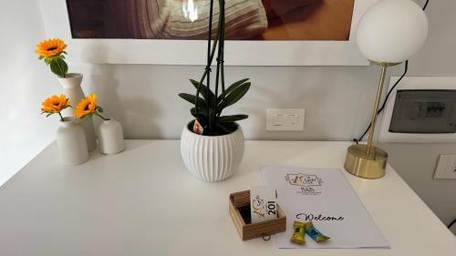 a white desk with flowers and a book on it at AC GOLD B&B Boutique Rooms & Suite in Reggio Calabria