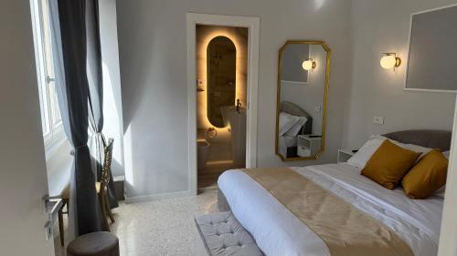 a bedroom with a large bed and a mirror at AC GOLD B&B Boutique Rooms & Suite in Reggio Calabria